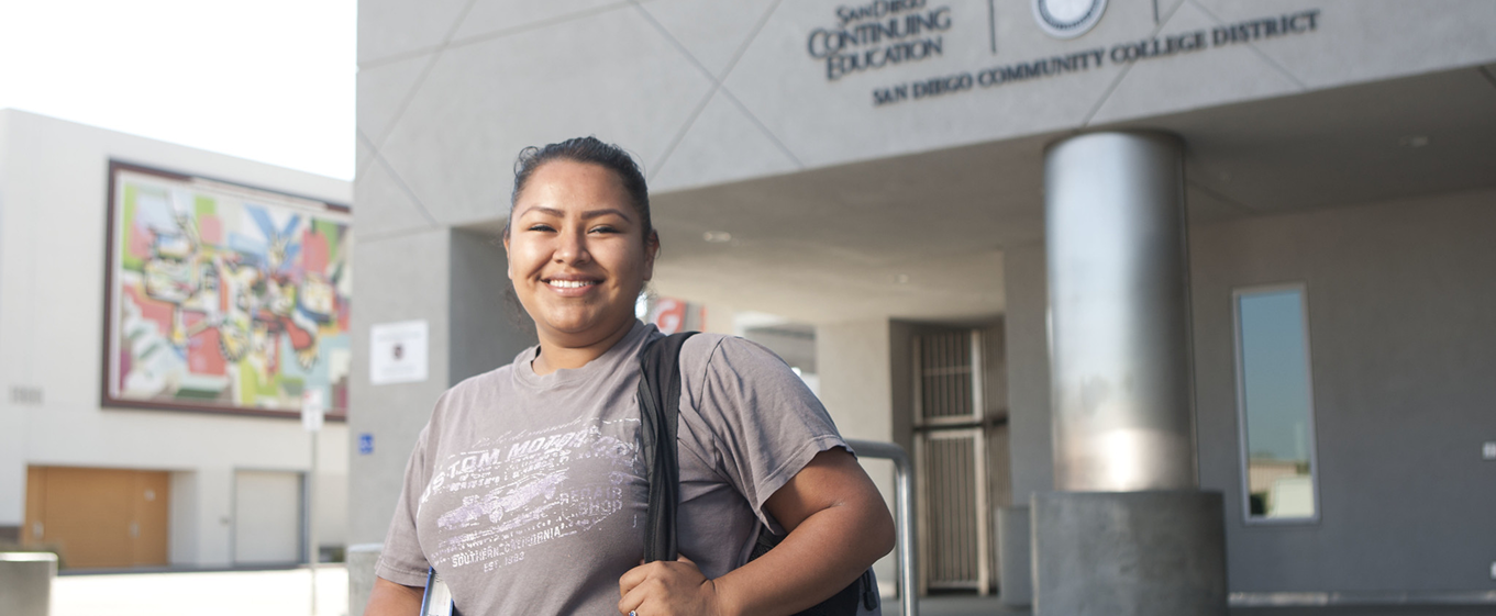 Female student holding backpack in college building