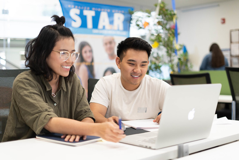 Two students looking at a laptop