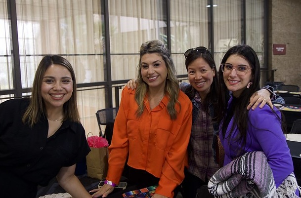 Three females inside a building posing for a picture